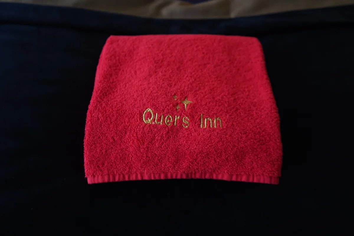 Ein rotes Frotteetuch mit der Aufschrift «Quers Inn».